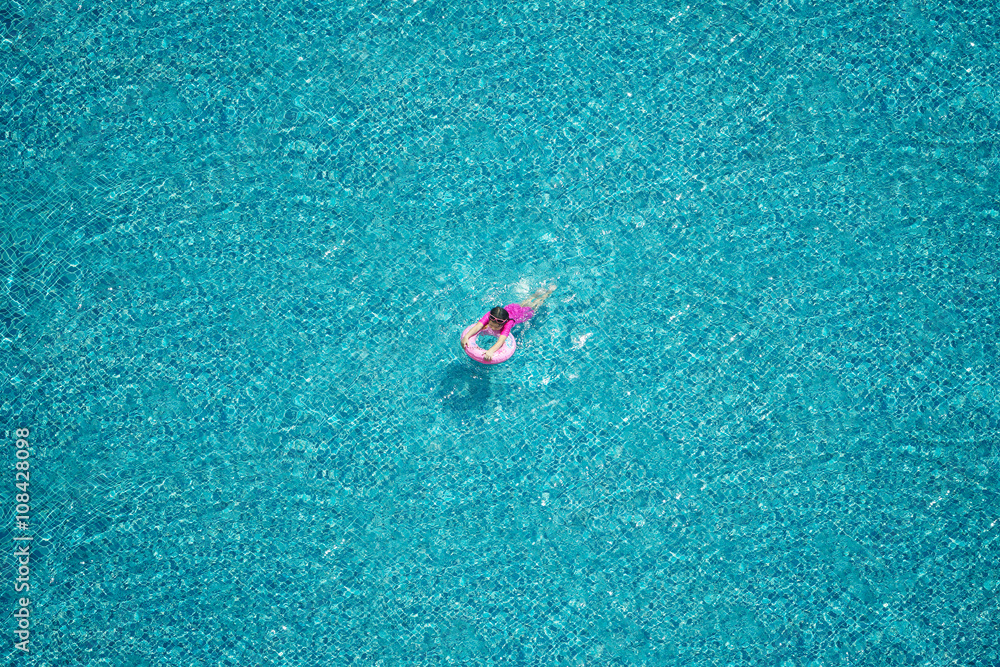 Top view of girl swimming in the pool.