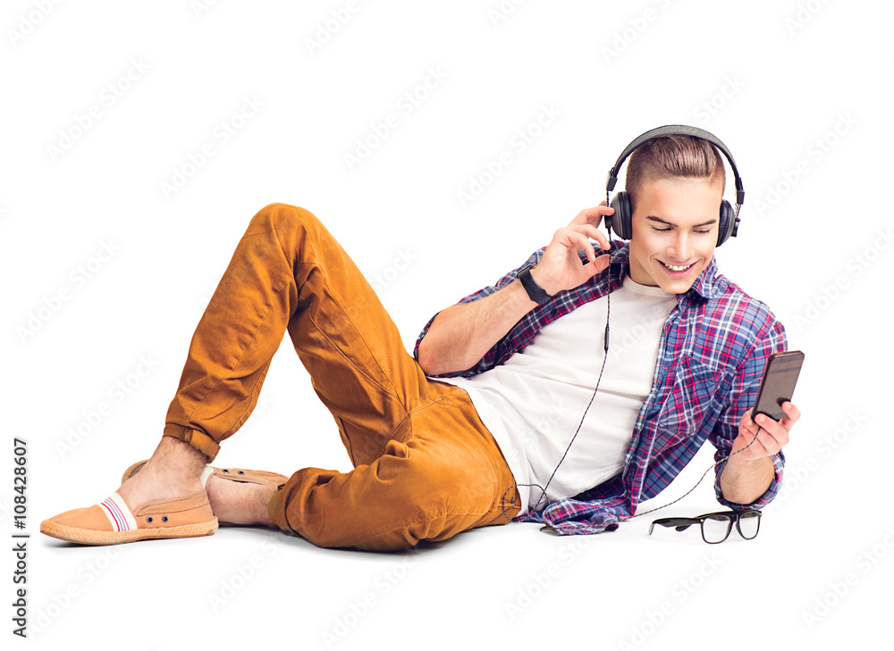 Handsome young man listening to music in headphones with smartphone