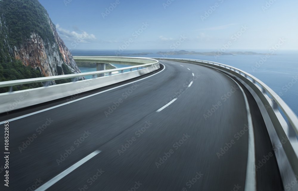 Highway overpass motion blur with coast skyline background .