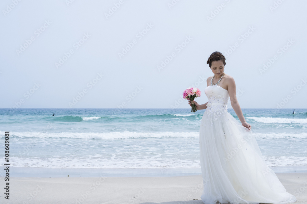 Bride wearing a wedding dress are in the beach