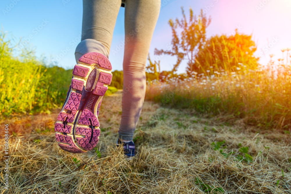 Woman running at sunset in a field