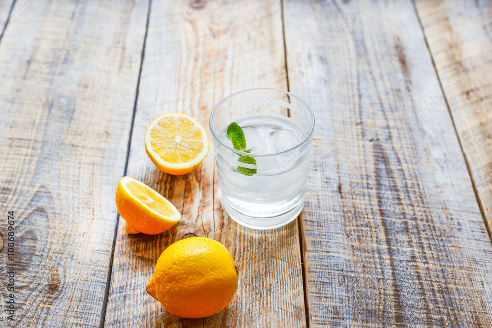 glass of lemonade with  lemons on wooden table