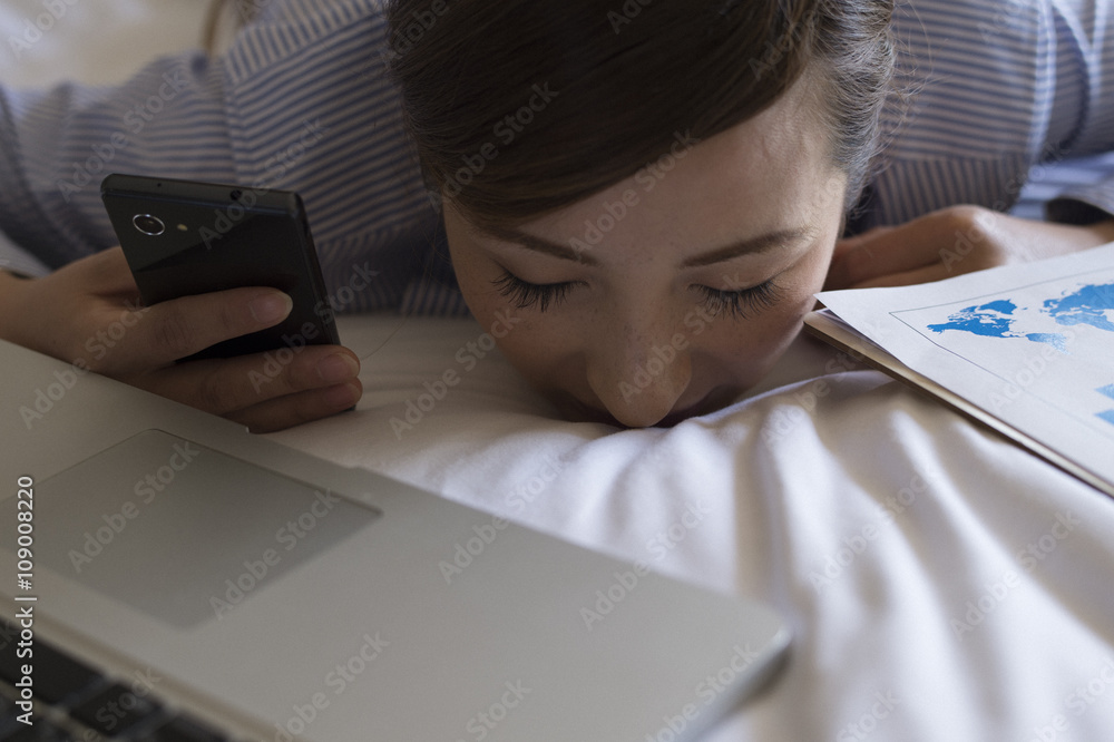 Business woman is sleeping lying face down on a bed in a hotel room