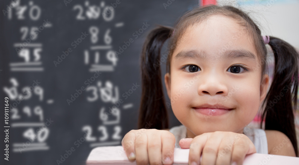 happy schoolgirl , childhood and education concept - happy little girl with chalk drawing Mathematic