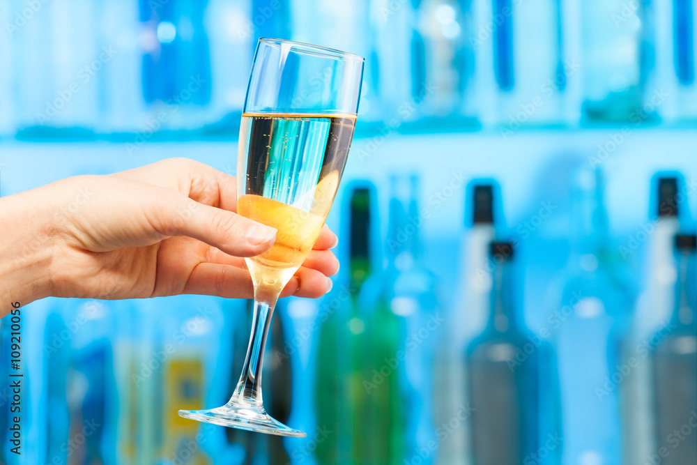 Woman hand toasting champagne in crystal glass