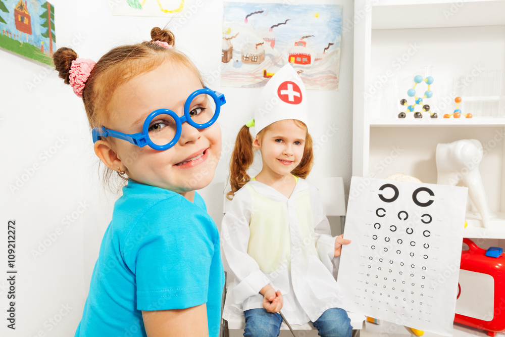 Girl in blue toy glasses at ophthalmologist room