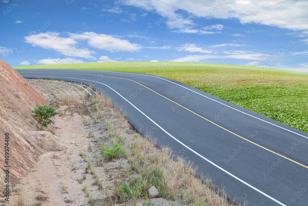 Asphalt Road with green grass ,blue sky  background.