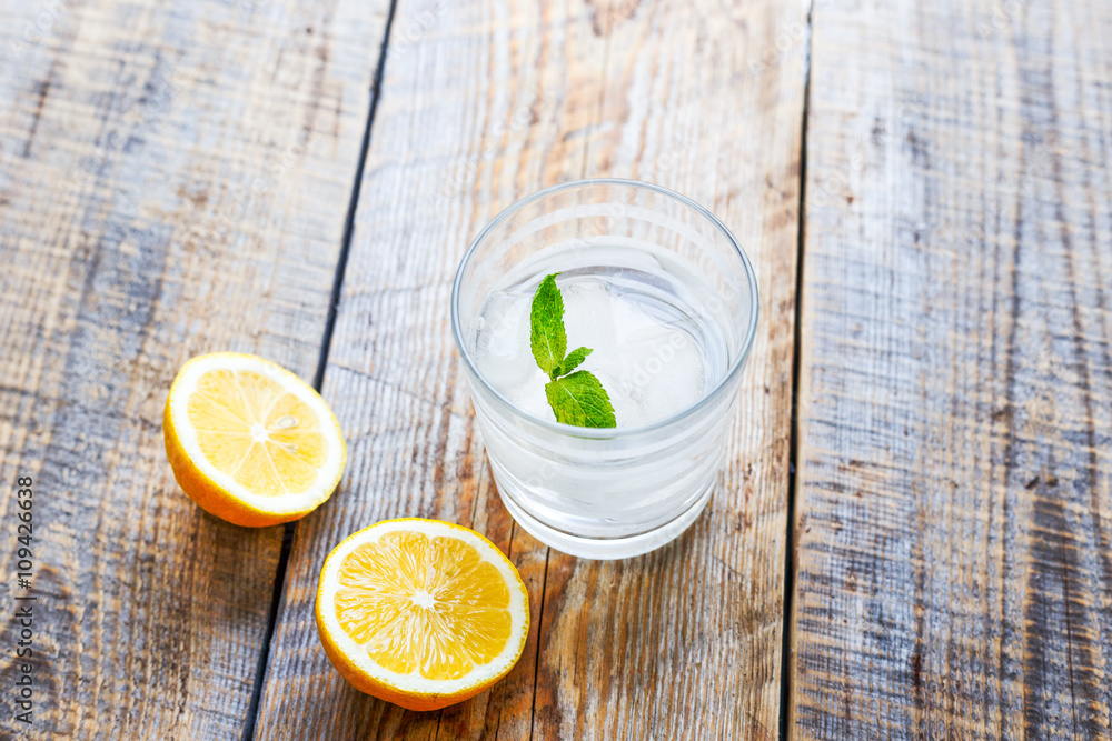 glass of lemonade with  lemons on wooden table close up