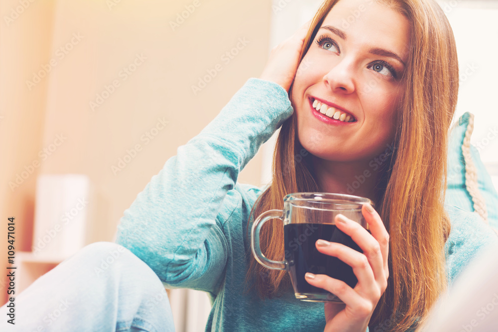 Happy young woman drinking coffee