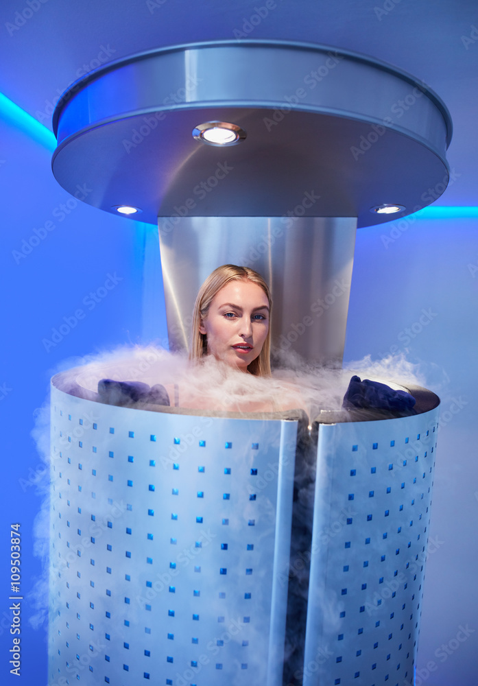 Beautiful woman in a full body cryotherapy camber