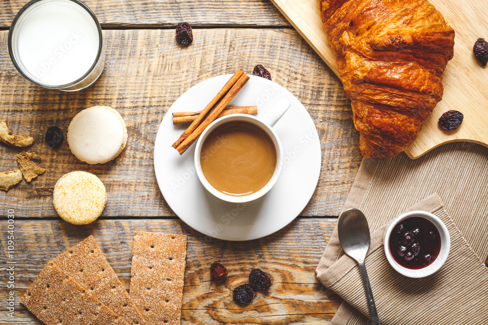 Breakfast with coffee, crackers and croissants on wooden table