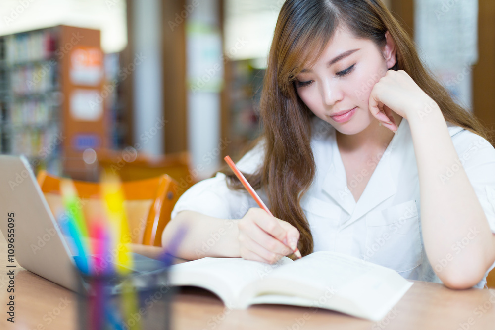 young beautiful asian girl student in library