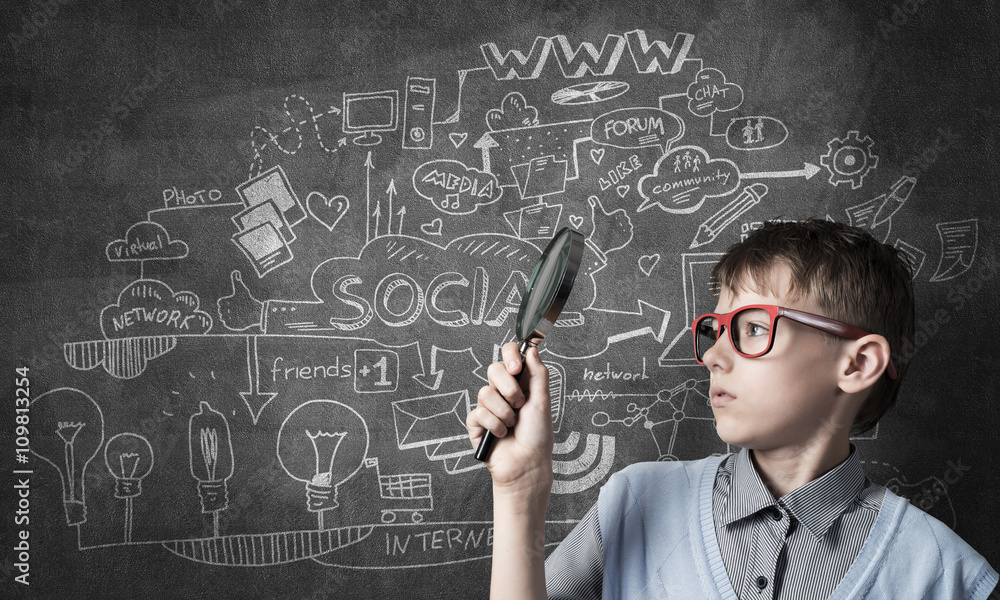 Curious school boy with magnifier