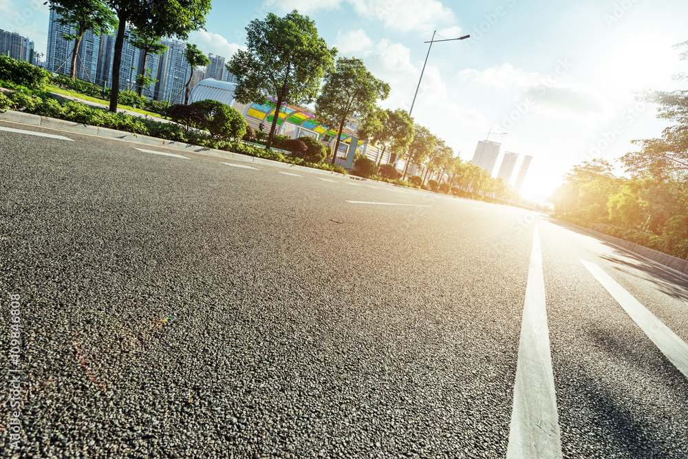 empty asphalt road in modern city at sunrise