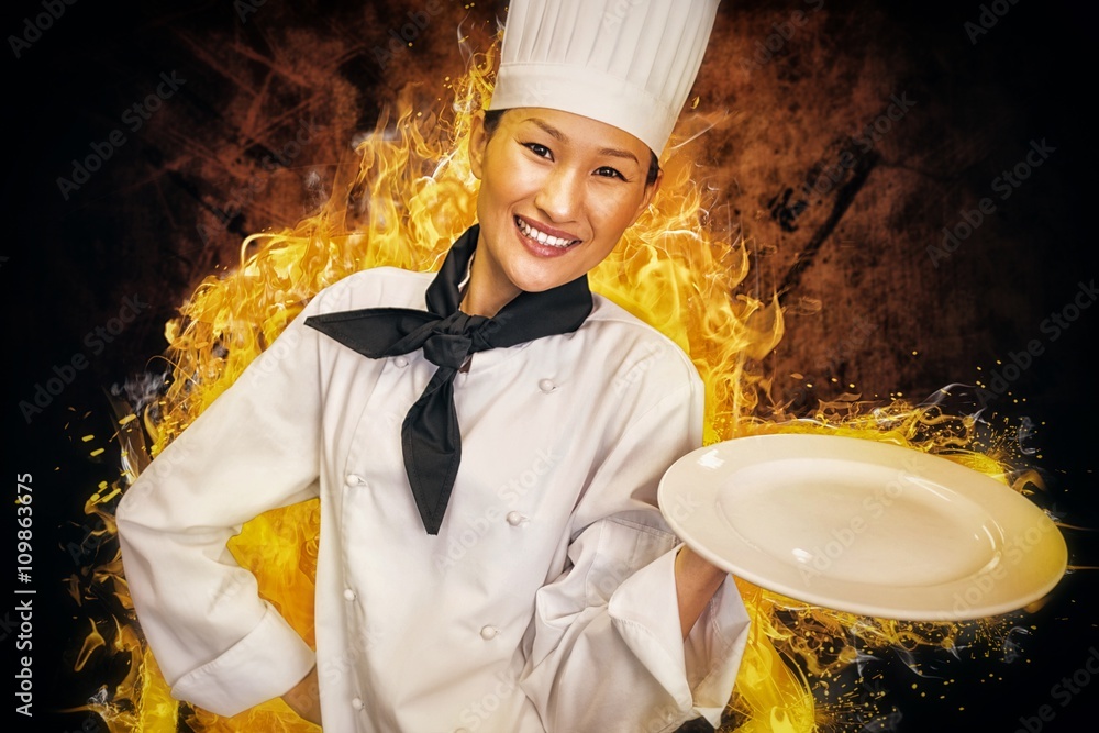 Composite image of smiling female cook holding empty plate in ki