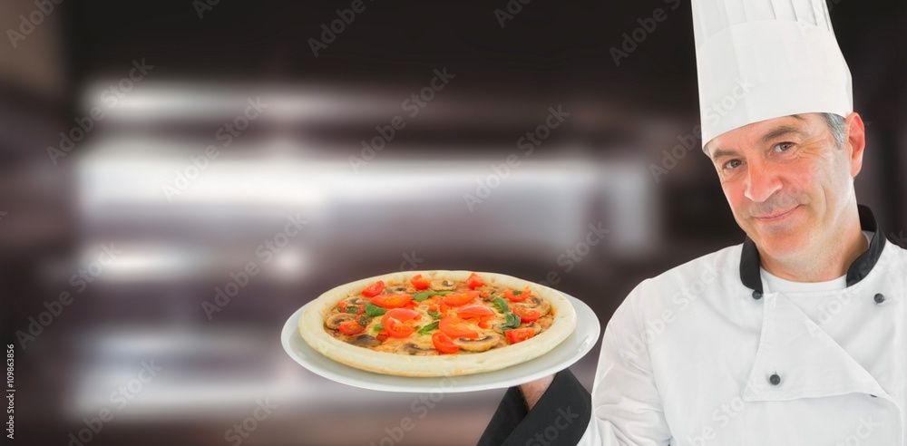 Composite image of friendly chef holding a pizza