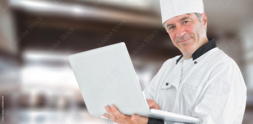 Composite image of friendly chef holding a laptop