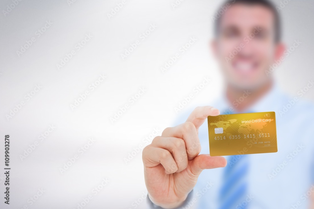 Composite image of happy businessman showing a creditcard