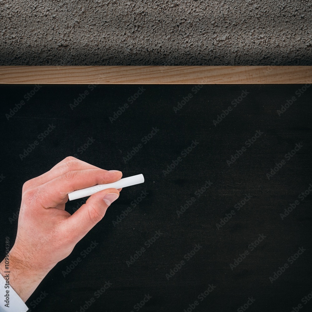 Composite image of businessman writing with white chalk 