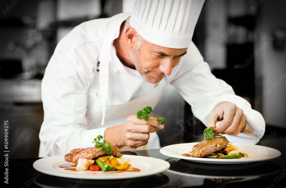 Concentrated male chef garnishing food in kitchen