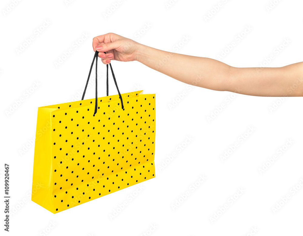 hand holding yellow gift bag isolated on white background