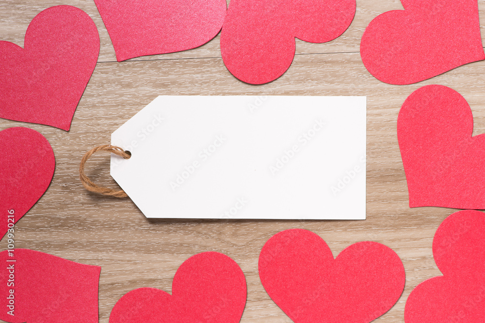 Paper tag with Red Valentines Day heart shaped paper border on wooden background