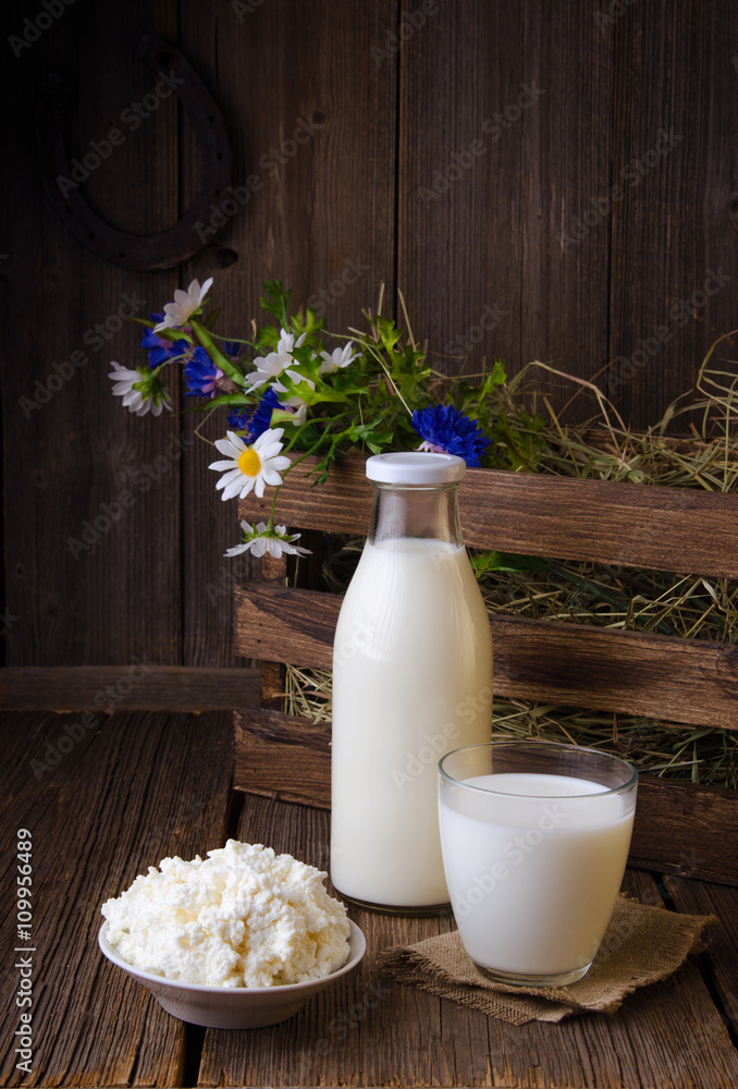 A bottle of rustic milk and glass of milk on a wooden table