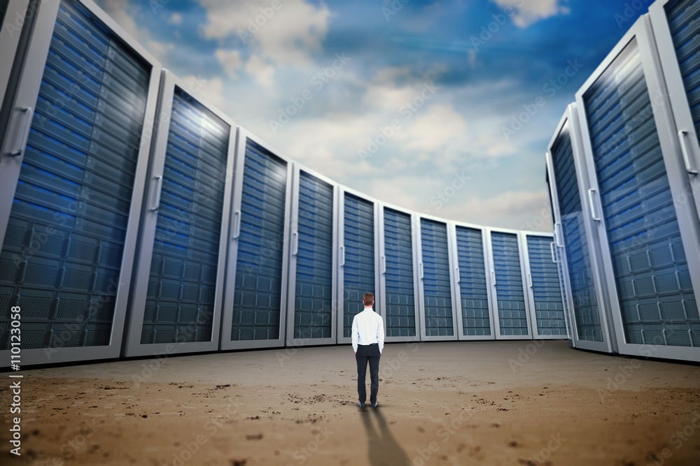 Composite image of rear view of businessman with hands in pocket