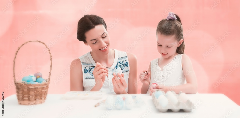 Composite image of mother and daughter painting easter eggs