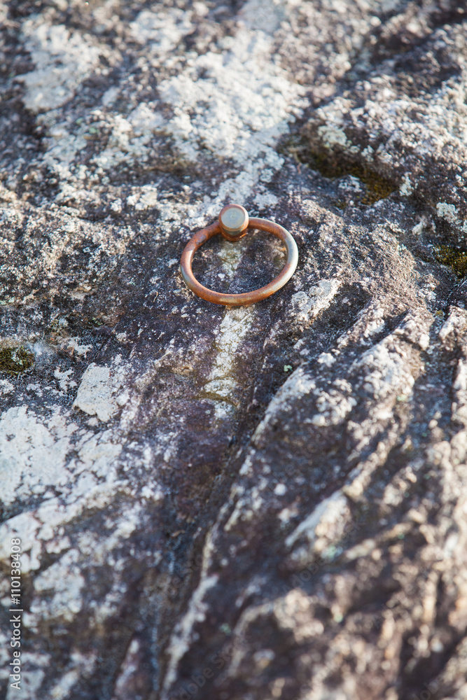 Metal ring climbing equipment at stone cliff