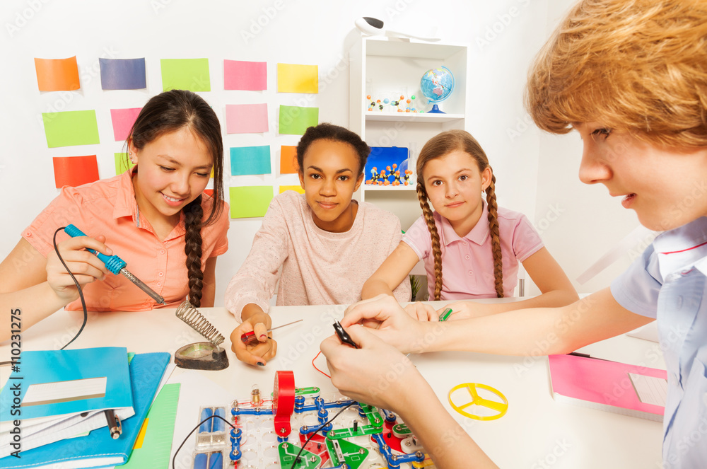 Girl soldering a component onto circuit board