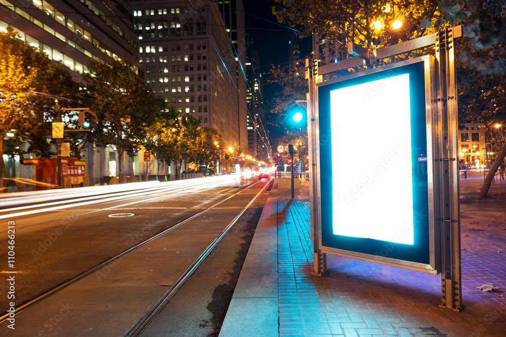 blank billboard on road with tramway in san francisco at night