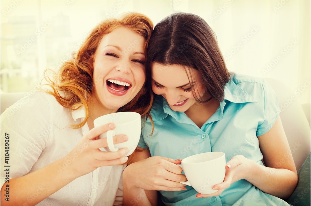 Friends with coffee cups enjoying a conversation at home