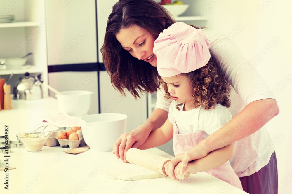 Mother and daughter using a rolling pin together