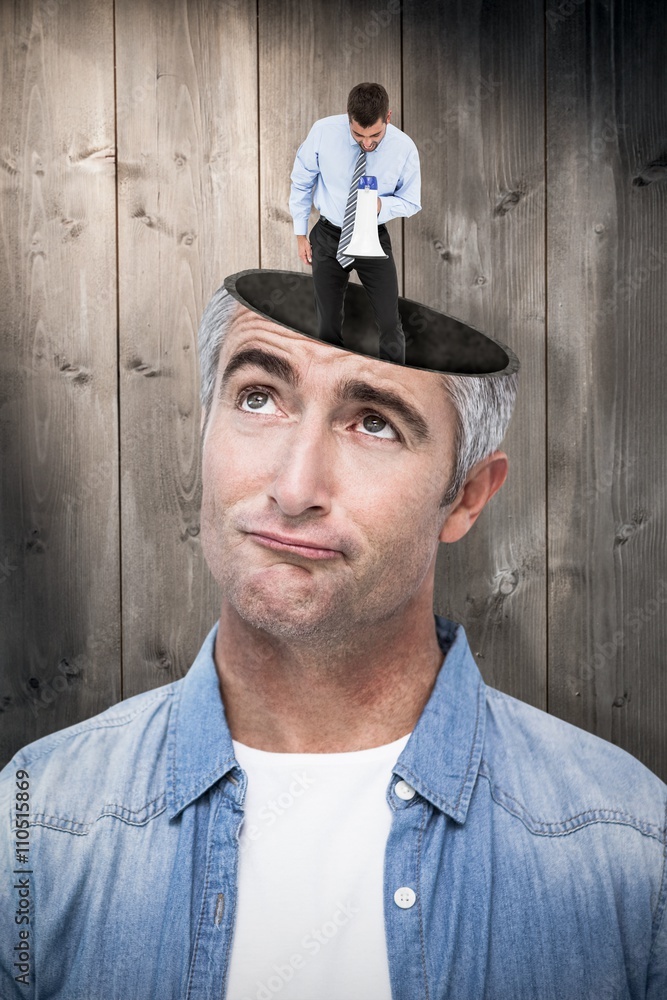 Composite image of businessman shouting through megaphone