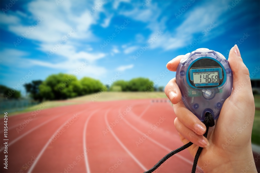 Composite image of close up of a hand holding a timer on a white