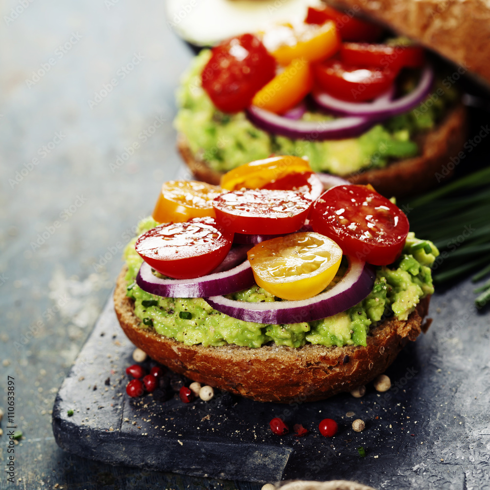 Tasty homemade sandwiches with avocado, tomato, onion and pepper