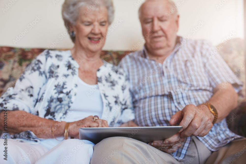 Happy senior couple using digital tablet