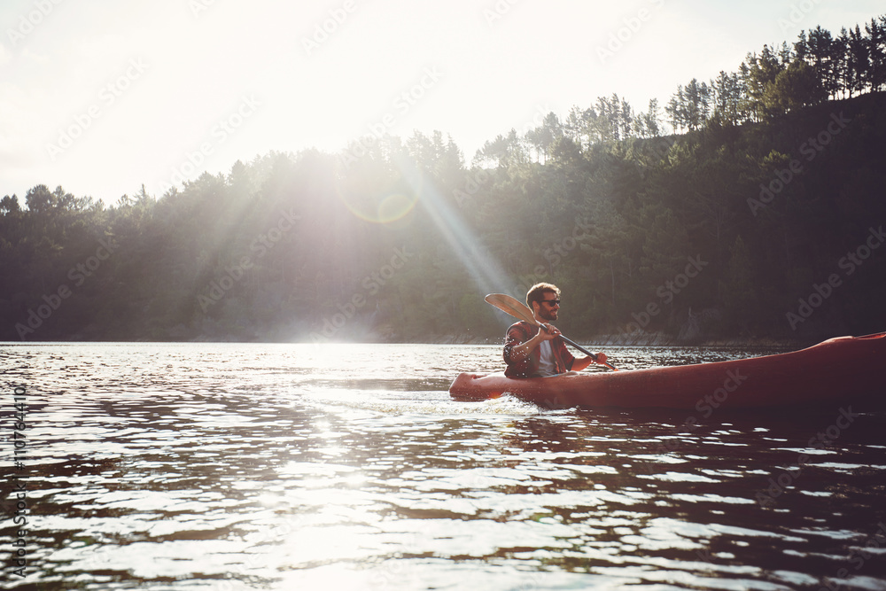 Man paddling kayak on a summer day