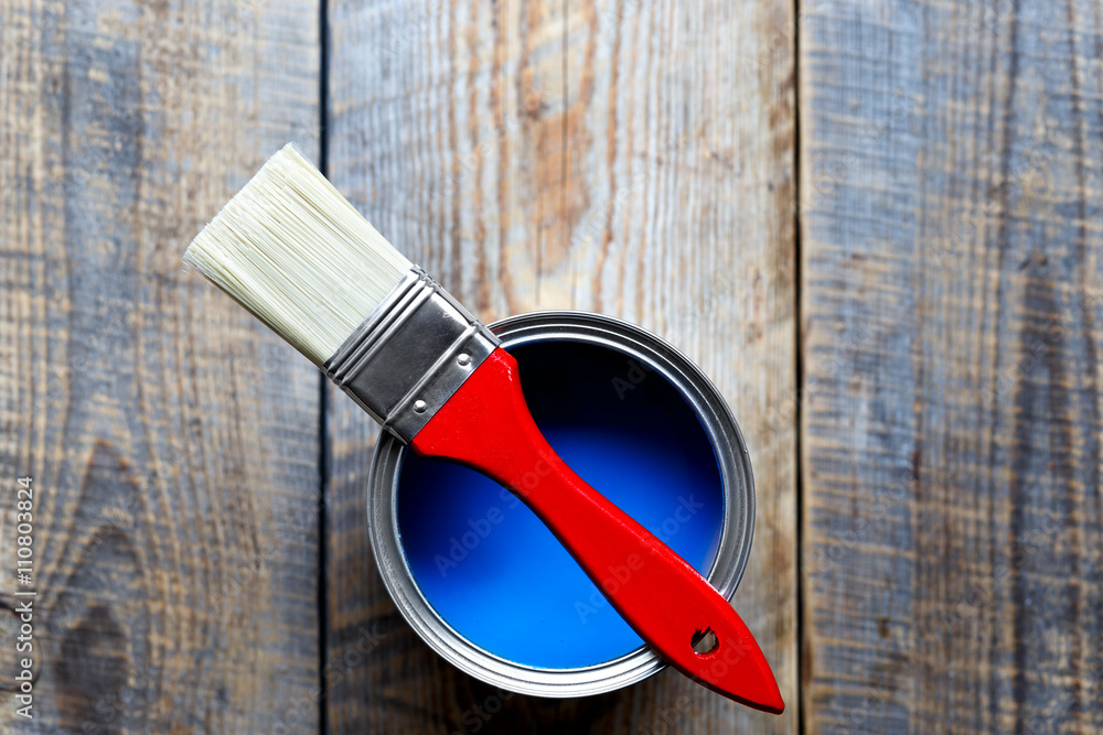 jar with blue paint on the wooden background top view