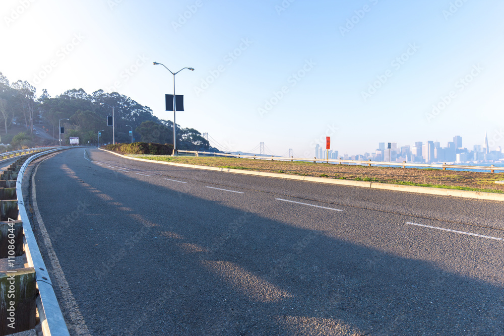 空荡荡的沥青乡村公路，拥有旧金山的城市景观和天际线