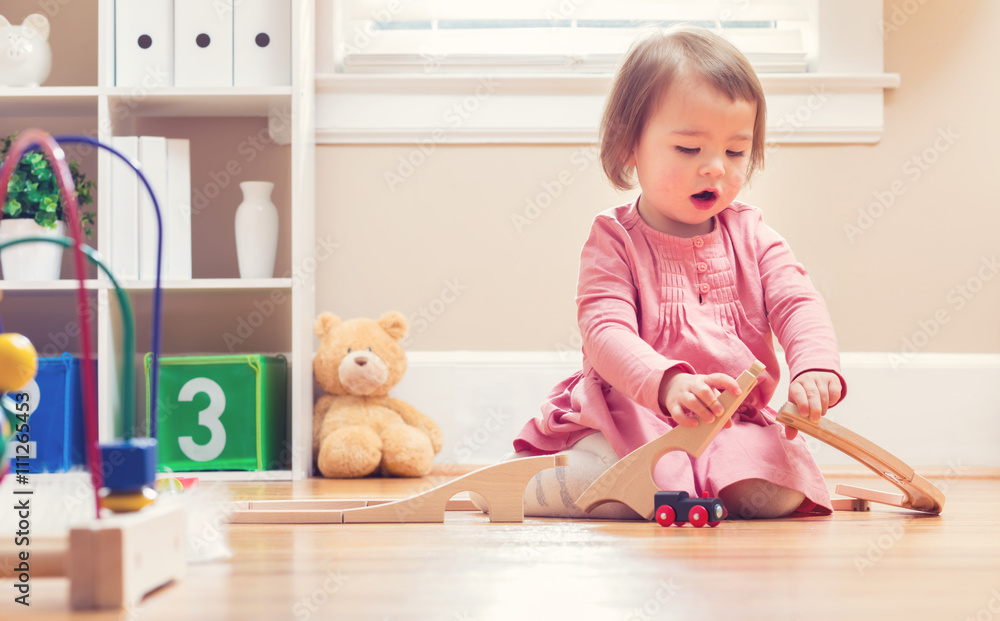 Happy toddler girl playing with toys