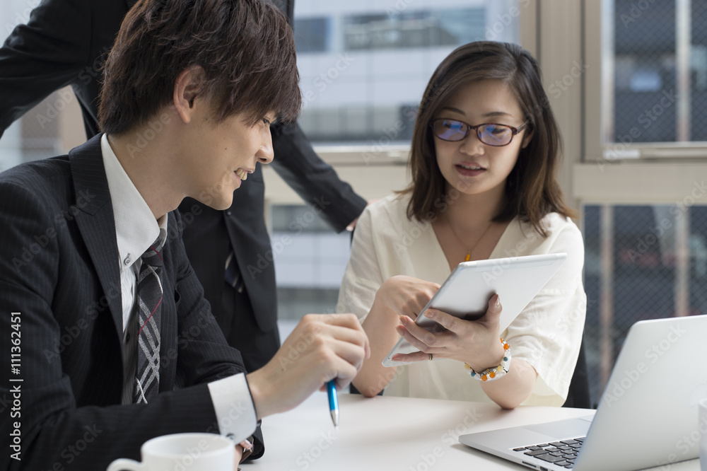 Three businessmen have a meeting to see the tablet