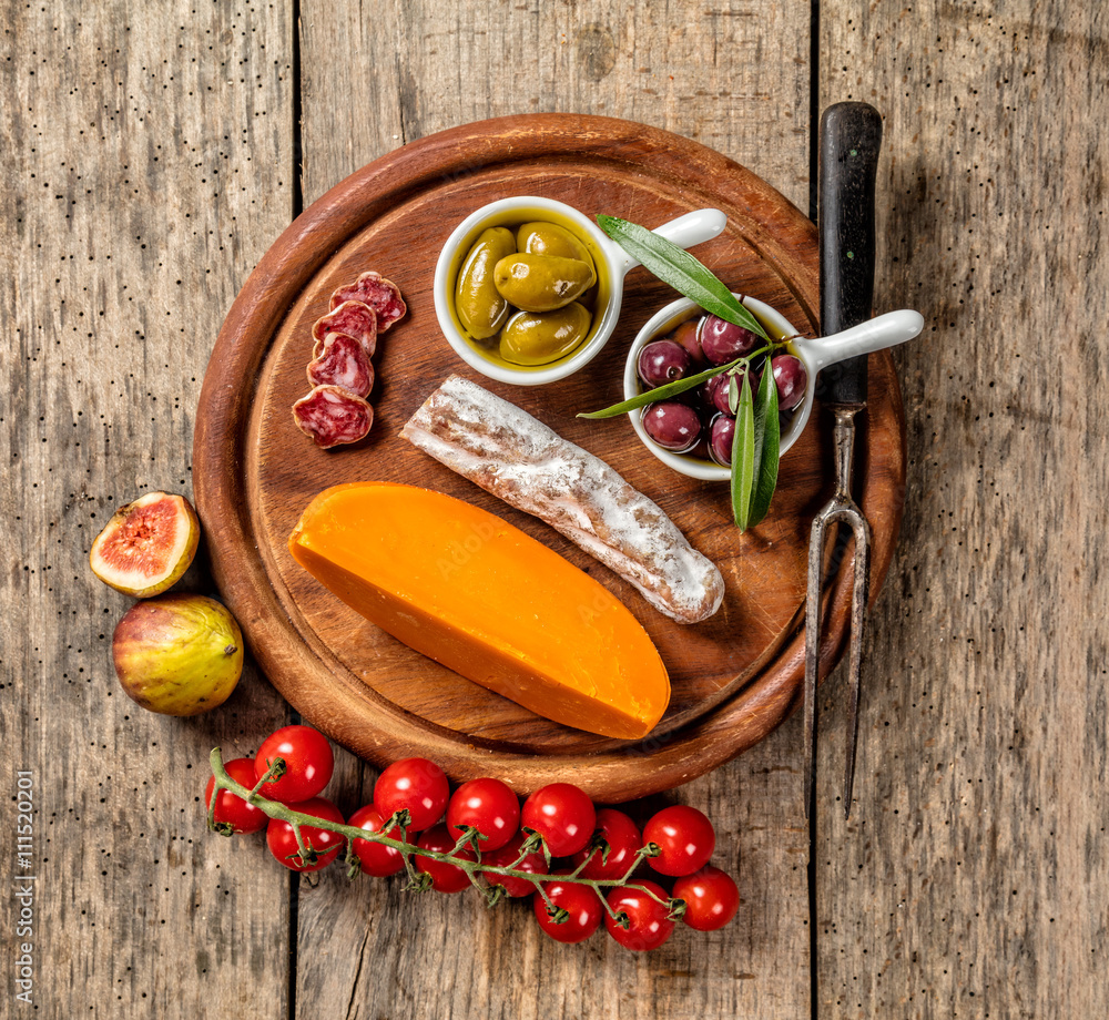 Various kind of cheese and delicacy on wood