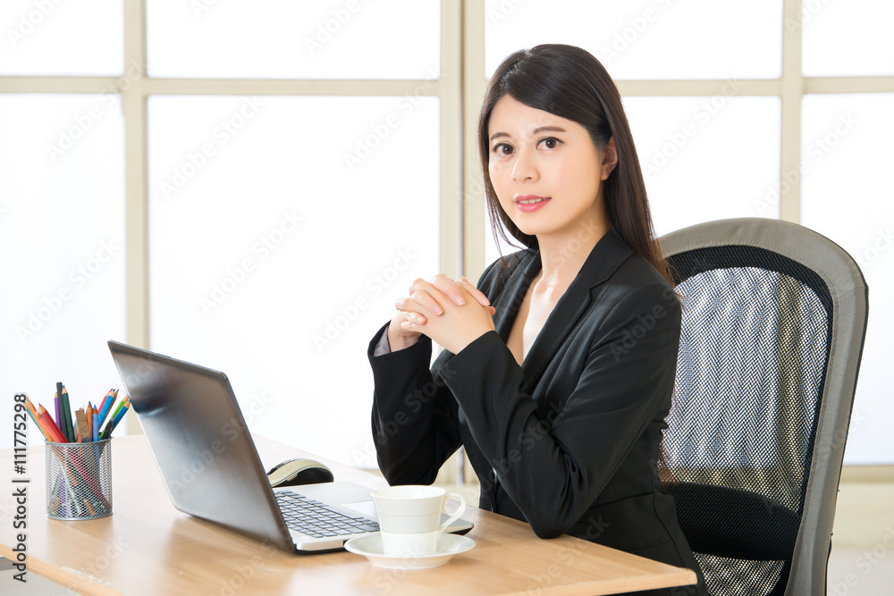 Young Asia businesswoman sitting and smiling at desk