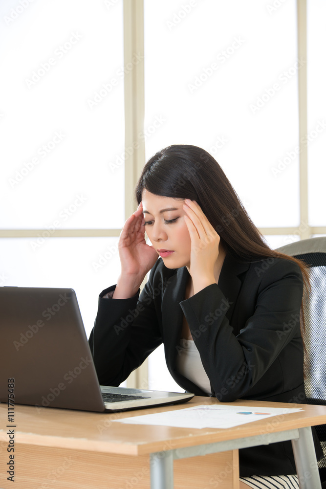 Tired asia businesswoman with headache in the office