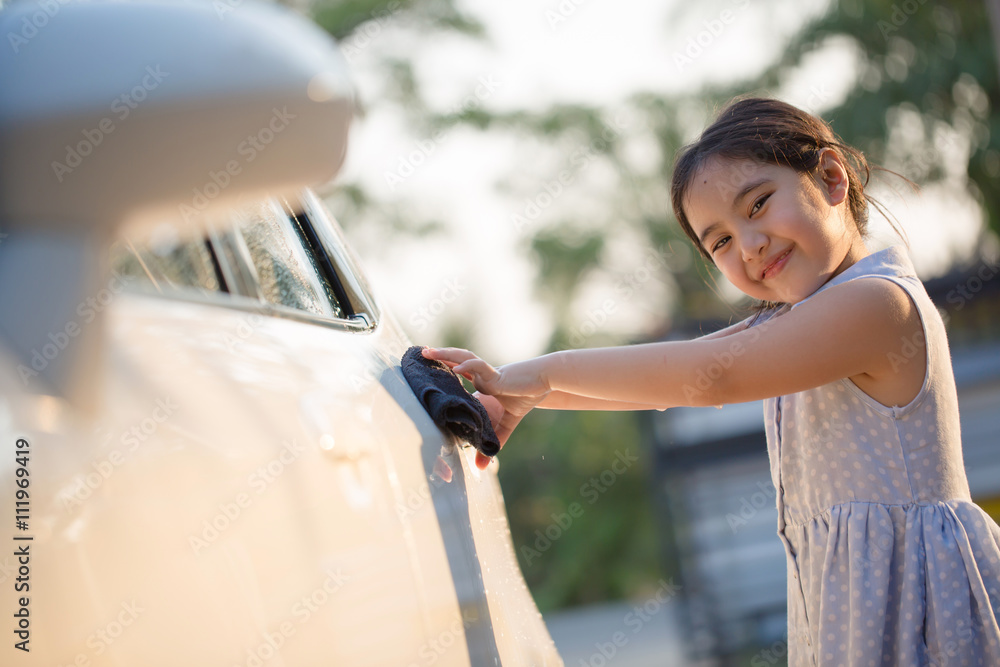 快乐的亚洲女孩在家泼水和阳光下洗车