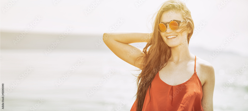 Young woman on the beach in hot summer sun light