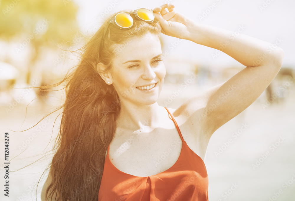 Young woman on the beach in hot summer sun light