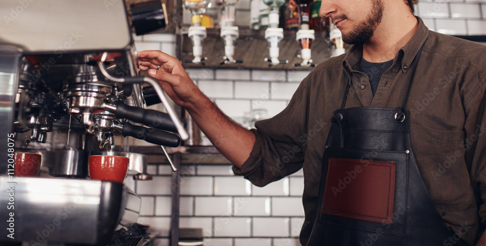 Barista using a coffee maker to make a nice cup of coffee